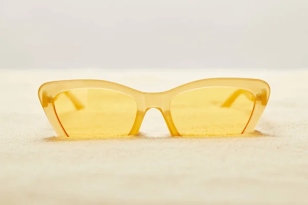 Foco Seletivo Óculos Sol Amarelos Areia Dourada Isolada Cinza — Fotografia de Stock