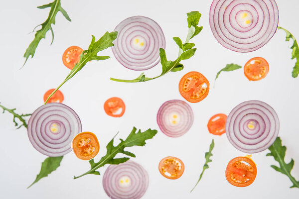 background with sliced tomatoes, red onions and green arugula leaves
