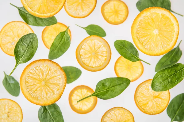 新鲜多汁的橘子片与绿色菠菜叶在灰色的背景 — 图库照片