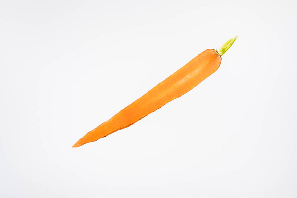 ломтик яркой спелой морковки на сером фоне
