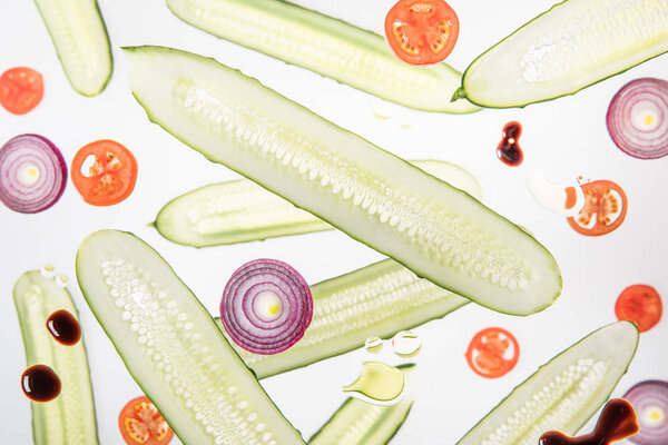 background with sliced tomatoes, cucumbers, red onions on grey