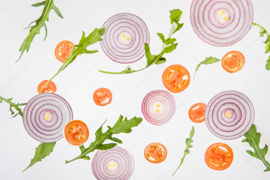 background with sliced red tomatoes, red onions and green arugula leaves