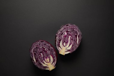 Top view of cut red cabbage on black surface clipart