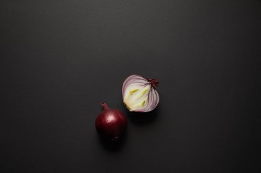 Top view of fresh cut onion on black surface clipart