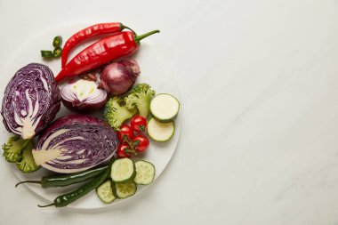 Top view of whole and cut vegetables on white surface clipart