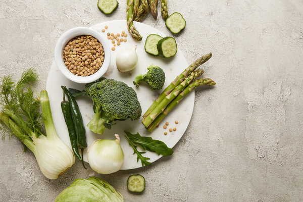 Top view of vegetables and seeds on grey textured surface