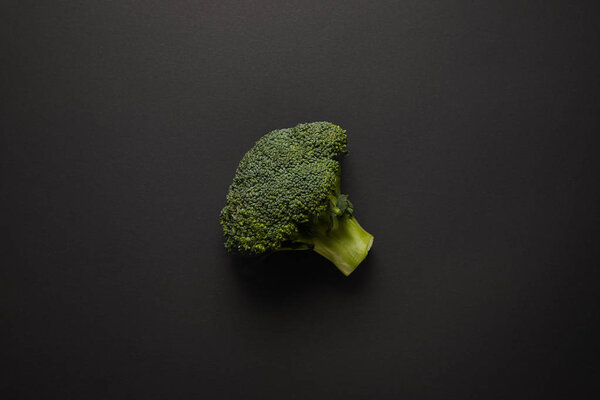 Top view of fresh green broccoli on black surface