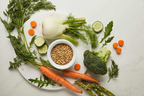 Flat lay with vegetables and seeds on white surface
