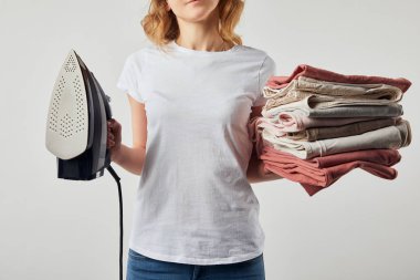 T-shirt tutan kısmi kadın demir ve katlanmış ütülü giysiler gri izole