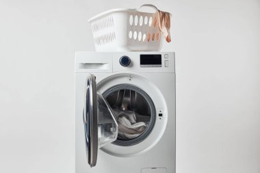 Washing machine with laundry basket isolated on grey clipart