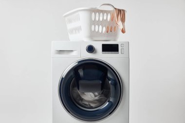 Gri üzerinde izole çamaşır sepeti ile yıkama makinesi