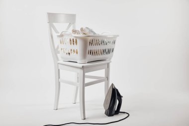 White chair, laundry basket with clothes and iron on grey clipart