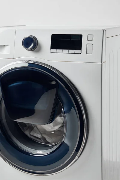 Modern washing machine with black display isolated on grey