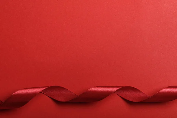 Верхний Вид Изогнутой Шелковой Красной Ленты Красном Фоне — стоковое фото