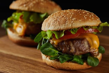 Ahşap Doğrama tahtası üzerinde peynir ve yeşillikler ile lezzetli et Burger seçici odak