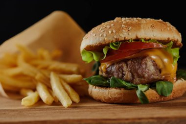 siyah üzerinde izole et ile patates kızartması ve lezzetli burger seçici odak
