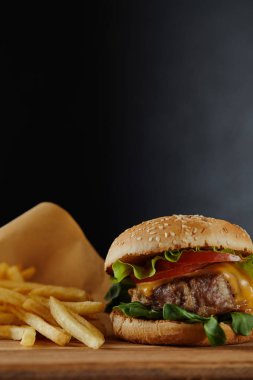 siyah arka planda et ve patates kızartması ile lezzetli burger seçici odak
