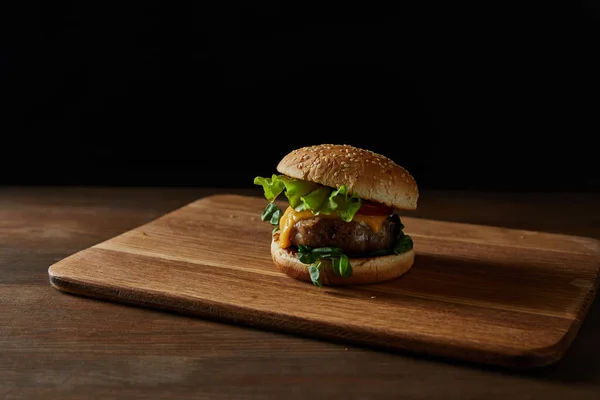 Färsk Välsmakande Kött Hamburgare Med Sesam Trä Skär Bräda Isolerad — Stockfoto