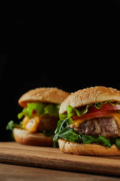 Foco Seletivo Deliciosos Hambúrgueres Carne Com Queijo Legumes Isolados Preto — Fotografia de Stock