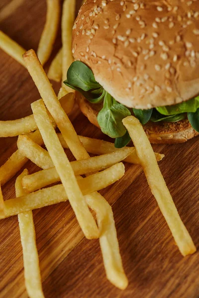 Νόστιμο Burger Πράσινο Και Σουσάμι Κοντά Τηγανητές Πατάτες Ξύλινη Επιφάνεια — Φωτογραφία Αρχείου