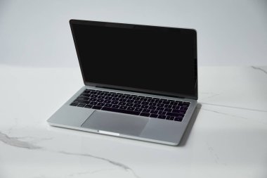 laptop with blank screen and black keyboard on white marble surface isolated on grey clipart
