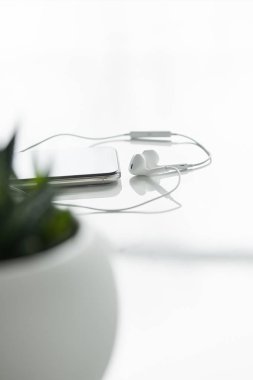 akıllı telefon ve beyaz üzerinde izole kablolu kulaklıklar seçici odak