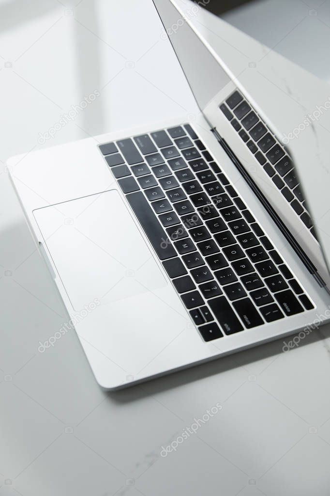 selective focus of laptop with black keyboard on white table