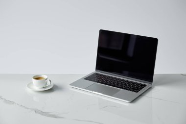 boş ekran ve gri üzerinde izole beyaz kahve bardağı ile Laptop