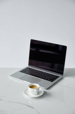 boş ekran ve siyah klavye ile laptop ve gri üzerinde izole kahve bardağı ile uçan
