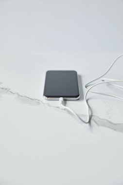 gri renkte yalıtılmış bağlı kablo ile boş ekran ile akıllı telefonun seçici odağı