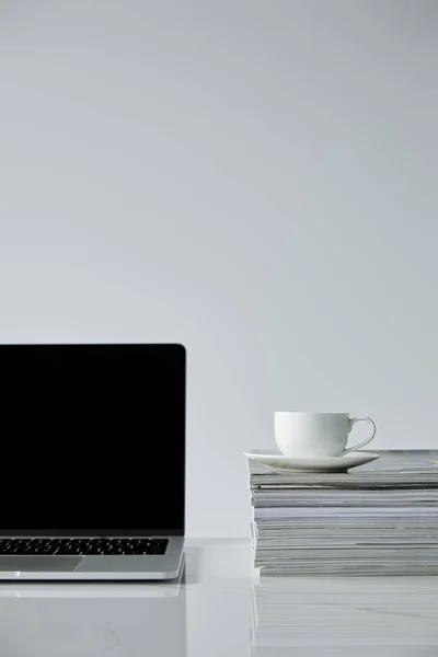 Laptop Mit Leerem Bildschirm Und Kaffeetasse Auf Einem Stapel Zeitschriften — Stockfoto