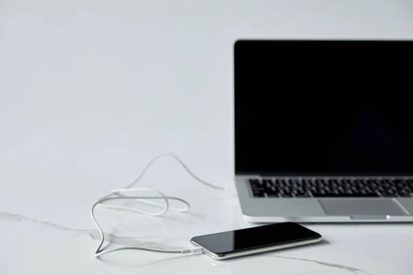 Селективный Фокус Смартфона Соединенный Кабелем Ноутбуку Чистым Экраном Изолированным Сером — стоковое фото