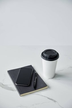Tek kullanımlık fincan, boş ekran ile Smartphone, siyah Notebook ve kalem üzerinde izole greysurface