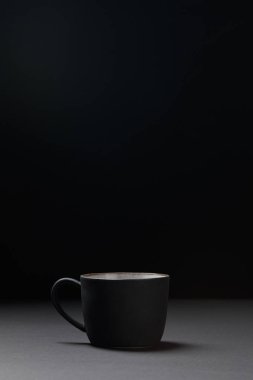 Siyah üzerinde koyu dokulu yüzeyde kahve bardağı