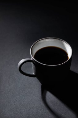 Koyu dokulu yüzeyde siyah kahve bardağı