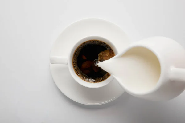 Draufsicht Auf Tasse Kaffee Und Kanne Milch Auf Weiß — Stockfoto