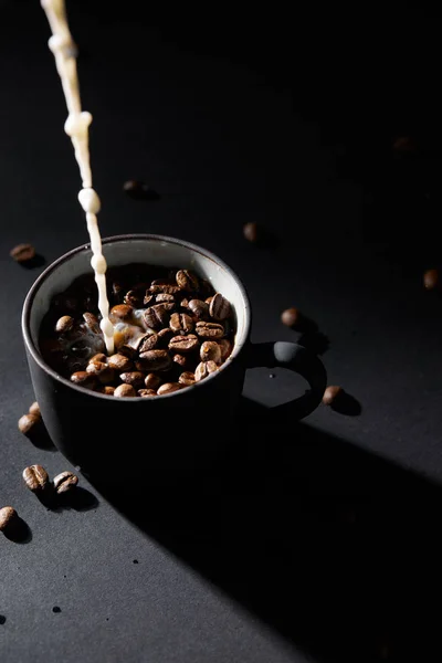 Kop Koffie Met Koffie Korrels Giet Melk Een Donkere Ondergrond — Stockfoto