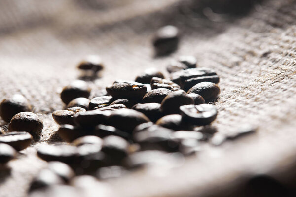 Selective focus of roasted coffee grains on sackcloth texture