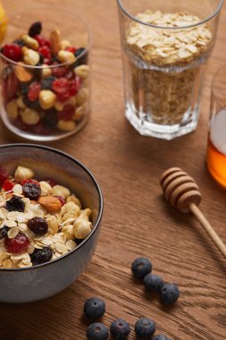 selective focus of cereal in bowl with nuts and dried berries prepared for breakfast clipart