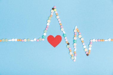 Renkli hap ve mavi kağıt kalp ile düz yatıyordu
