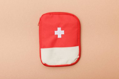 Top view of red first aid kit bag on brown surface clipart