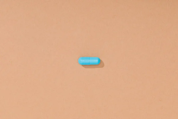 棕色表面上的蓝色药丸的顶视图 — 图库照片