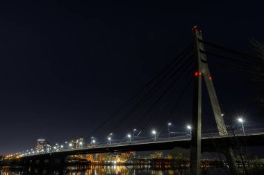Işıklı binalar ve köprü ile karanlık Cityscape 
