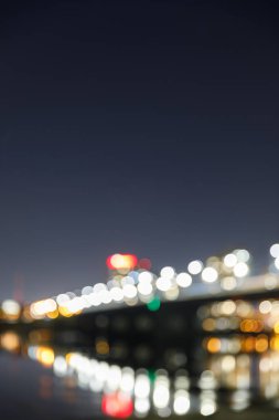blurred bokeh lights of illuminated buildings at night clipart
