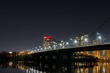 Geceleri nehir üzerinde ışıklı köprü ile Cityscape