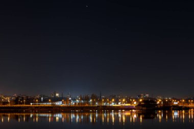 Geceleri binalar, ışıklar ve nehir ile karanlık Cityscape