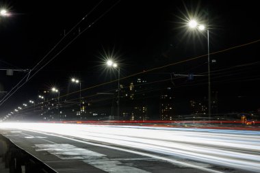long exposure of lights on road at night near buildings clipart