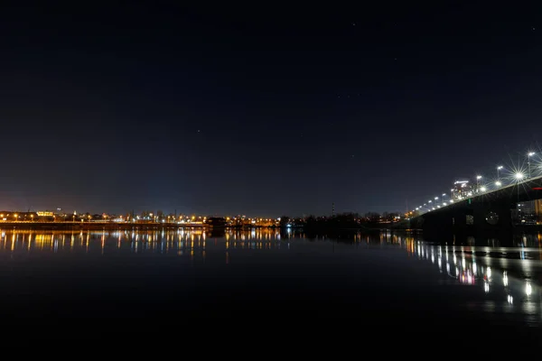 Donkere Stadsgezicht Met Gebouwen Brug Verlichting Rivier Nachtelijke Hemel — Stockfoto