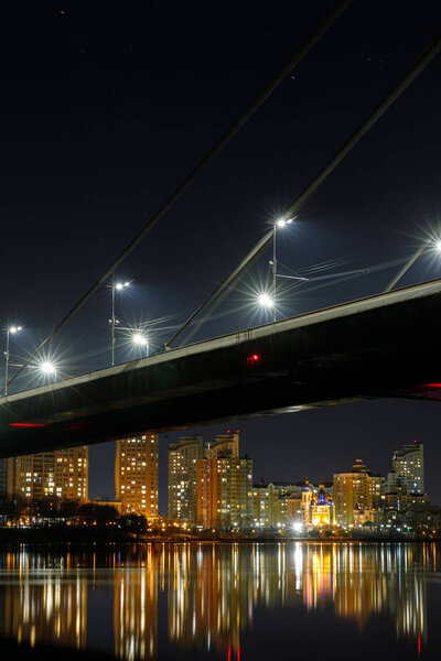 bridge, reflection on river and illuminated houses at night