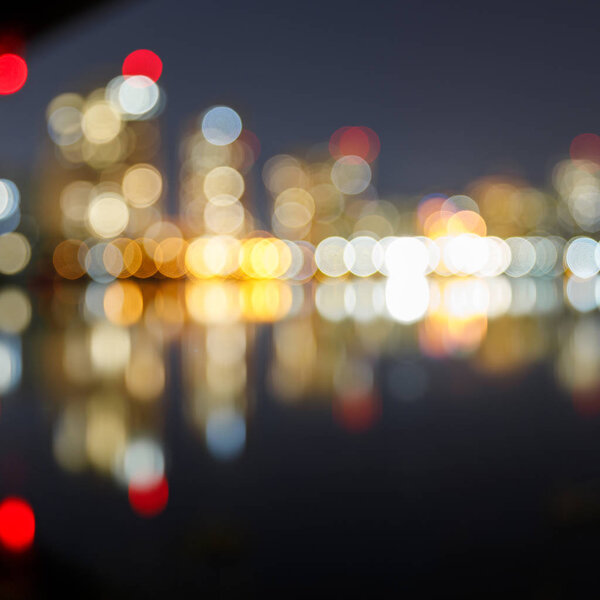 blurred illuminated buildings, reflection and bokeh lights